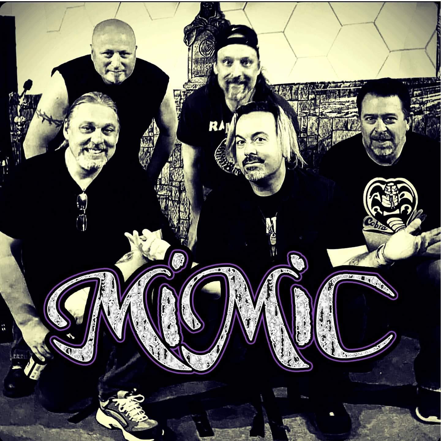 Five men pose together with Mimic written in large stylized letters across the image.